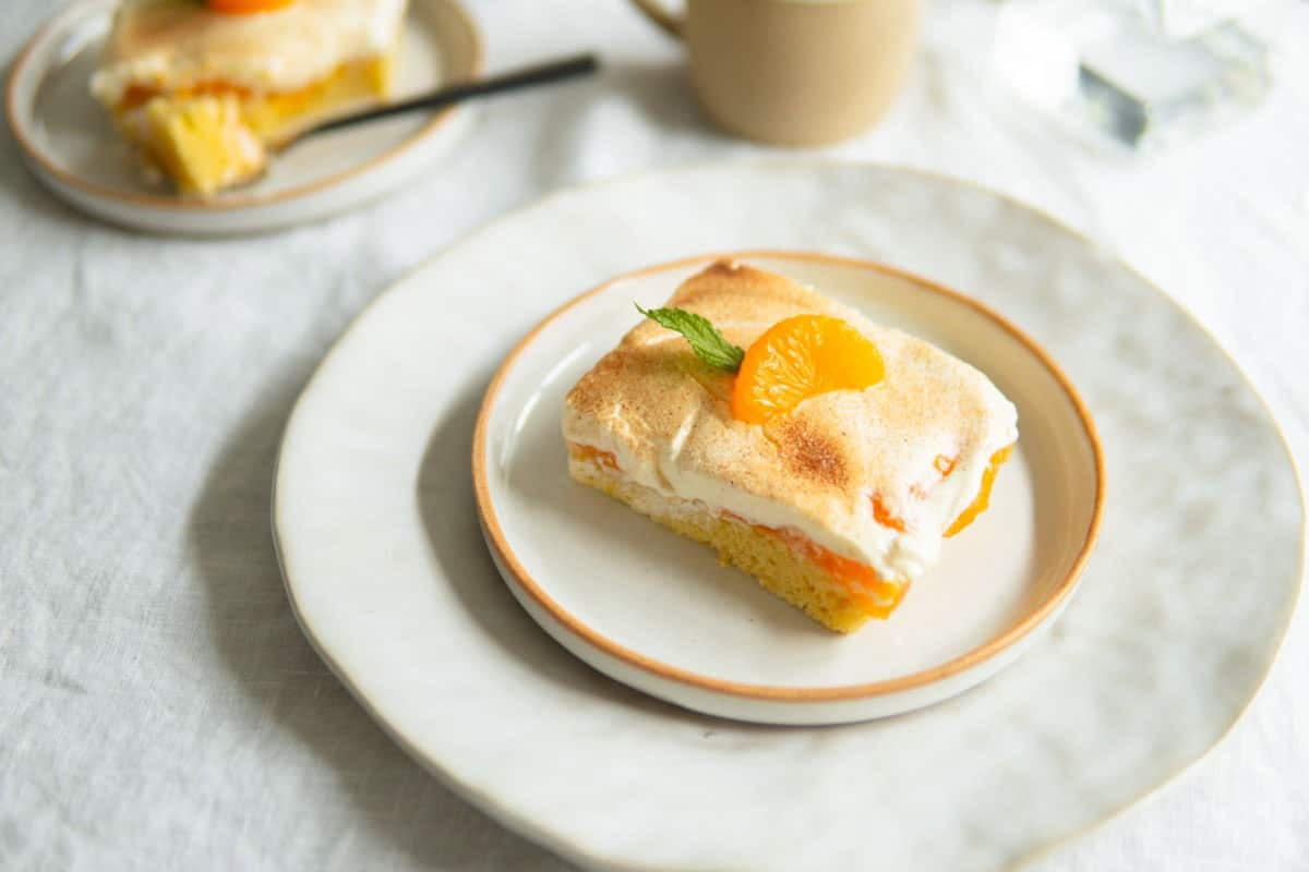 A slice of orange cake sitting on a plate.