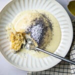 dampfnudel on a plate with vanilla sauce and poppy seed topping