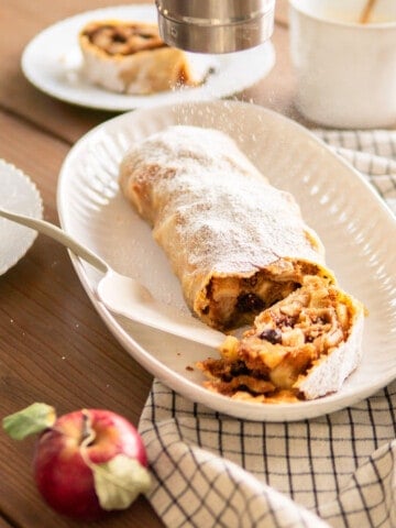 dusting apple strudel in powdered sugar