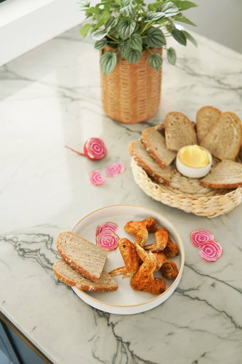 plate of chicken wings and a basket of sliced bread
