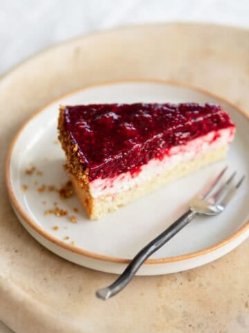 A slice of raspberry cake sitting on a plate.