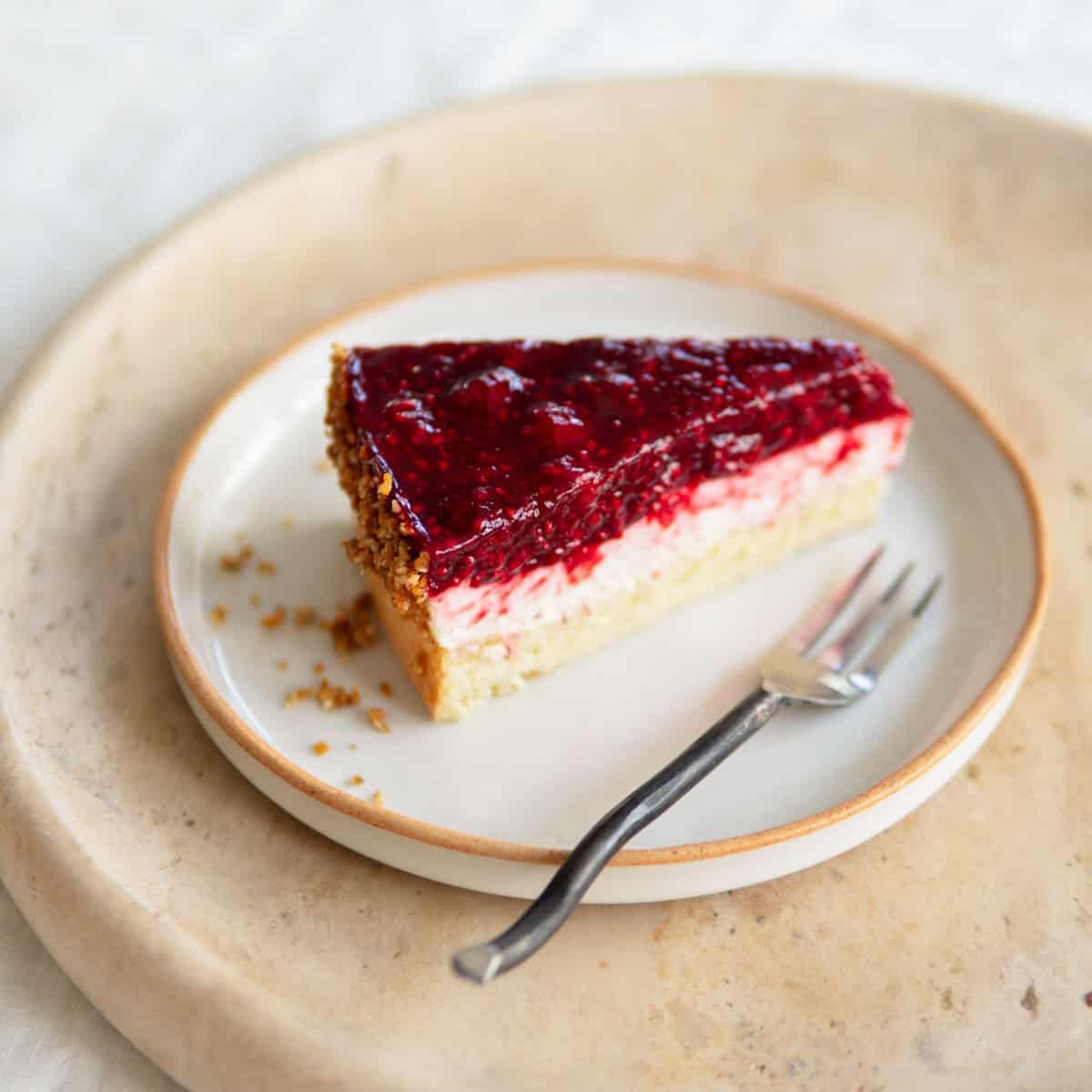 A slice of raspberry cake sitting on a plate.