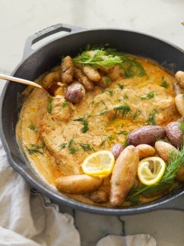 baked cod in a skillet with creamy mustard sauce