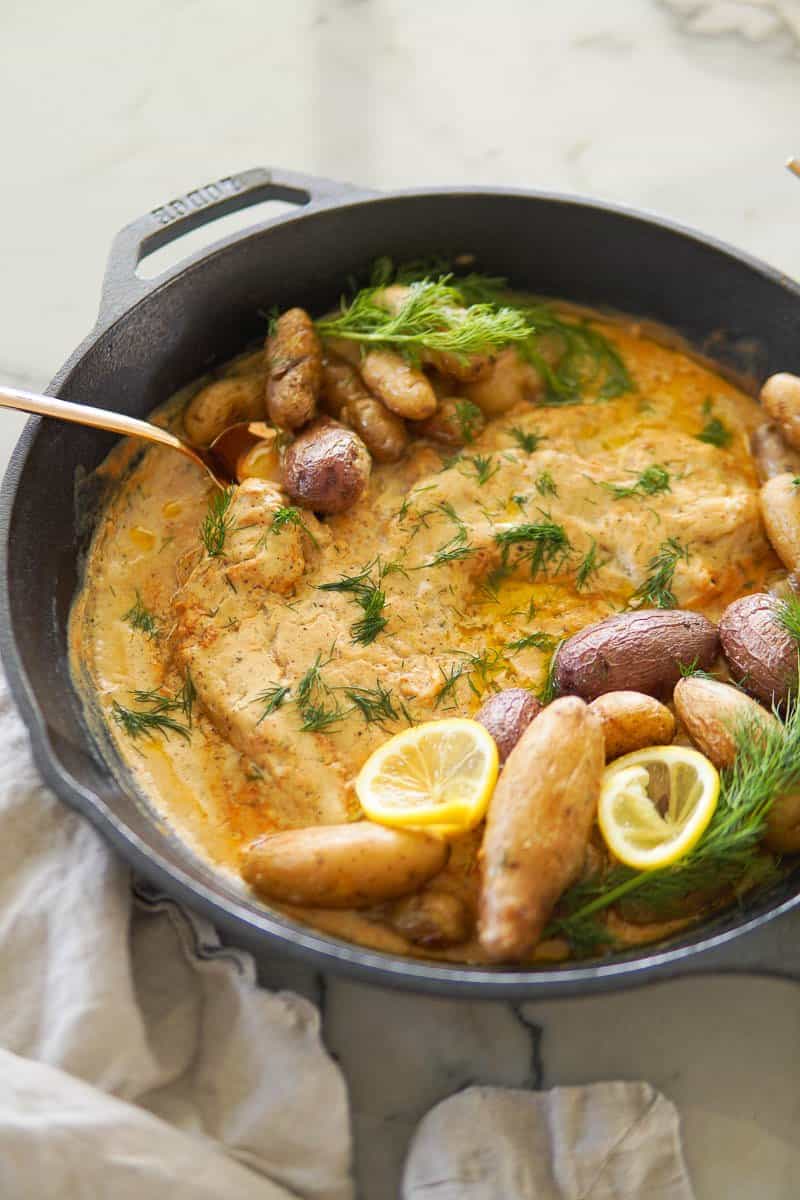 baked cod in a skillet with creamy mustard sauce