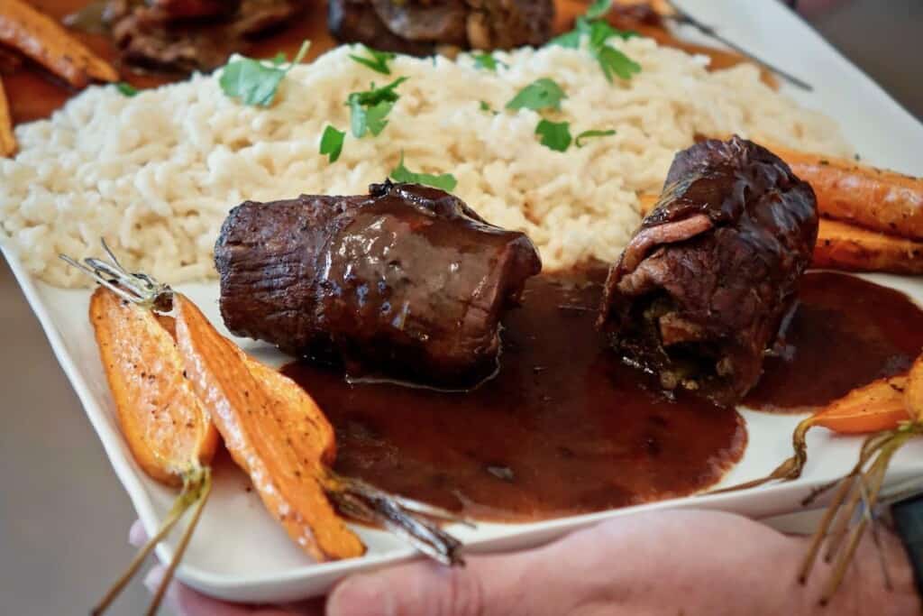 rinderrouladen on plate with spaetzle and roasted carrots