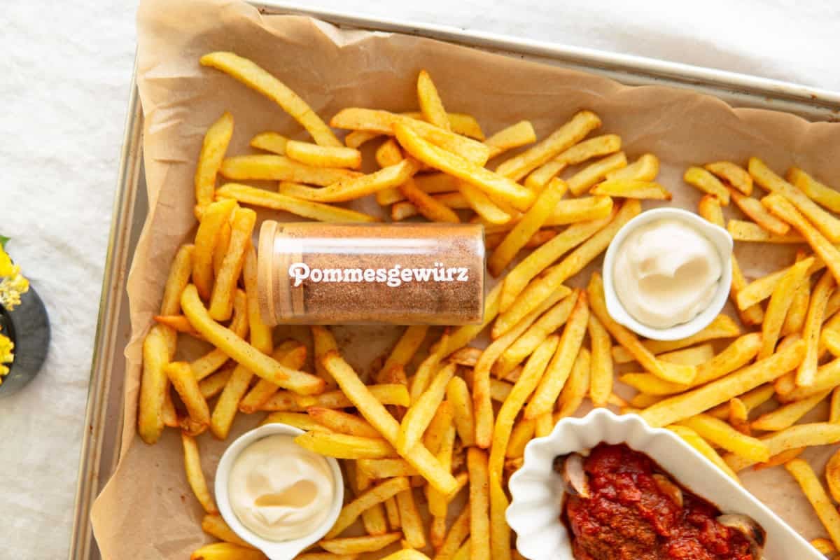 French fry seasoning jar surrounded by French fries.