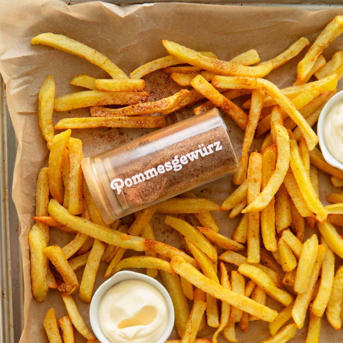 French fries on a baking sheet with French fry seasoning.
