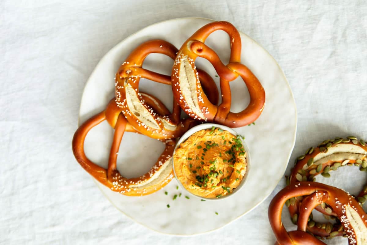 Obatzda beer cheese spread on a white plate with German pretzels