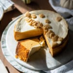 whole pumpkin cheesecake with one slice laying on its side