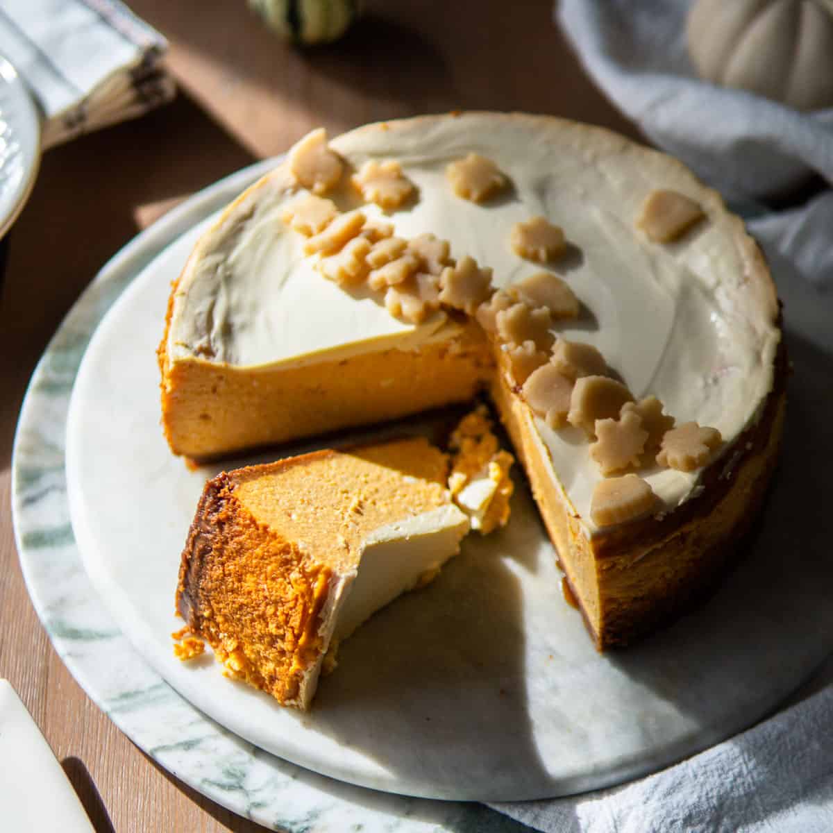 whole pumpkin cheesecake with one slice laying on its side
