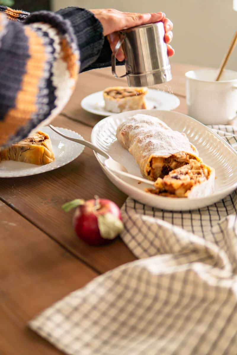 topping apple strudel with powdered sugar after baking