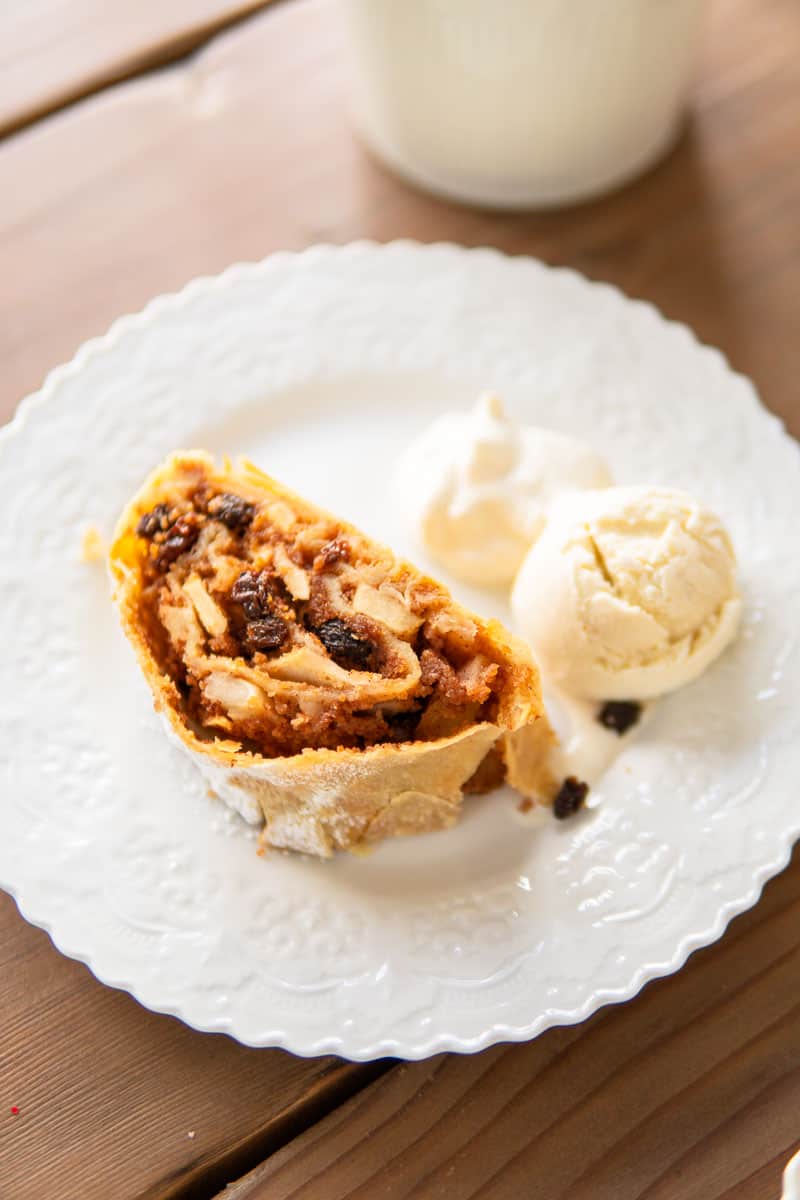 a slice of apple strudel on a plate with vanilla ice cream and whipped cream