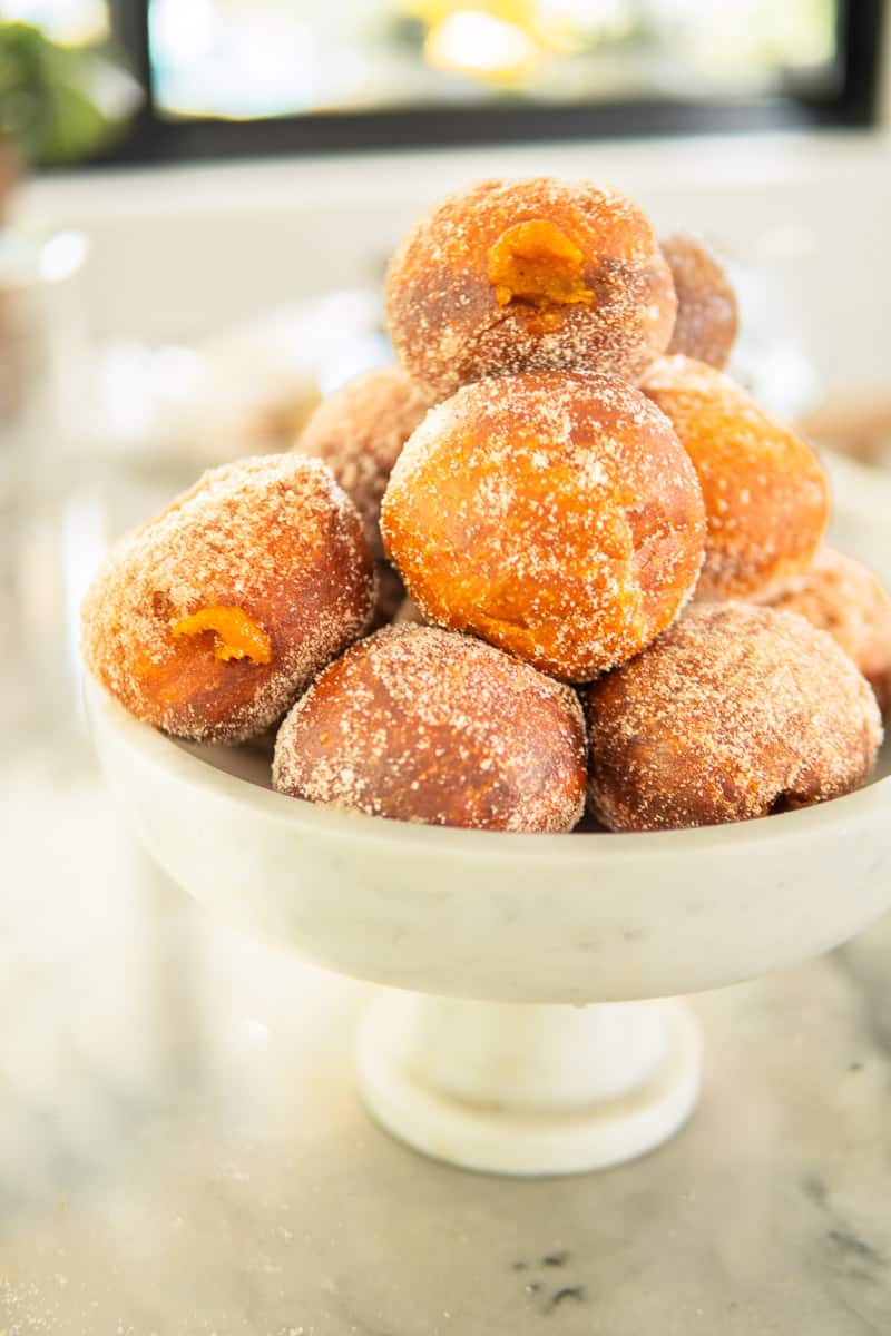 pumpkin donuts piled high on a footed server.