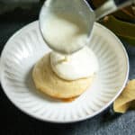 pouring vanilla sauce over German dessert dumplings.
