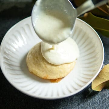 pouring vanilla sauce over German dessert dumplings.