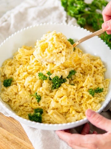 German spätzle noodles in a white serving bowl topped with parsley