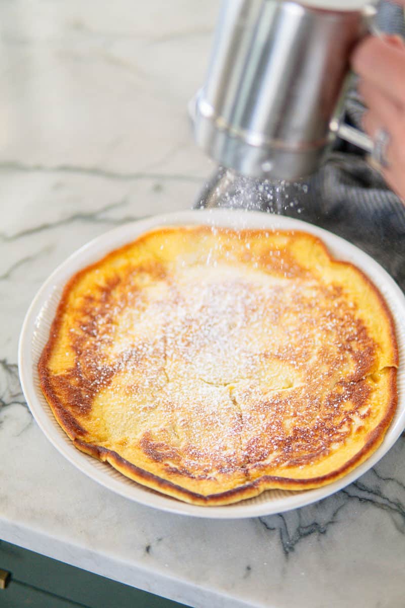 dusting German pancakes with powdered sugar