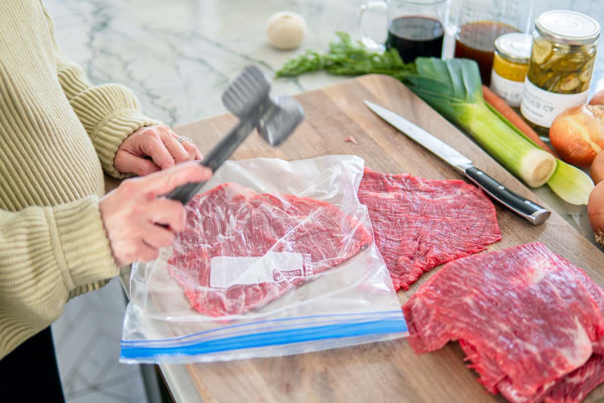 flattening the steak with a meat hammer