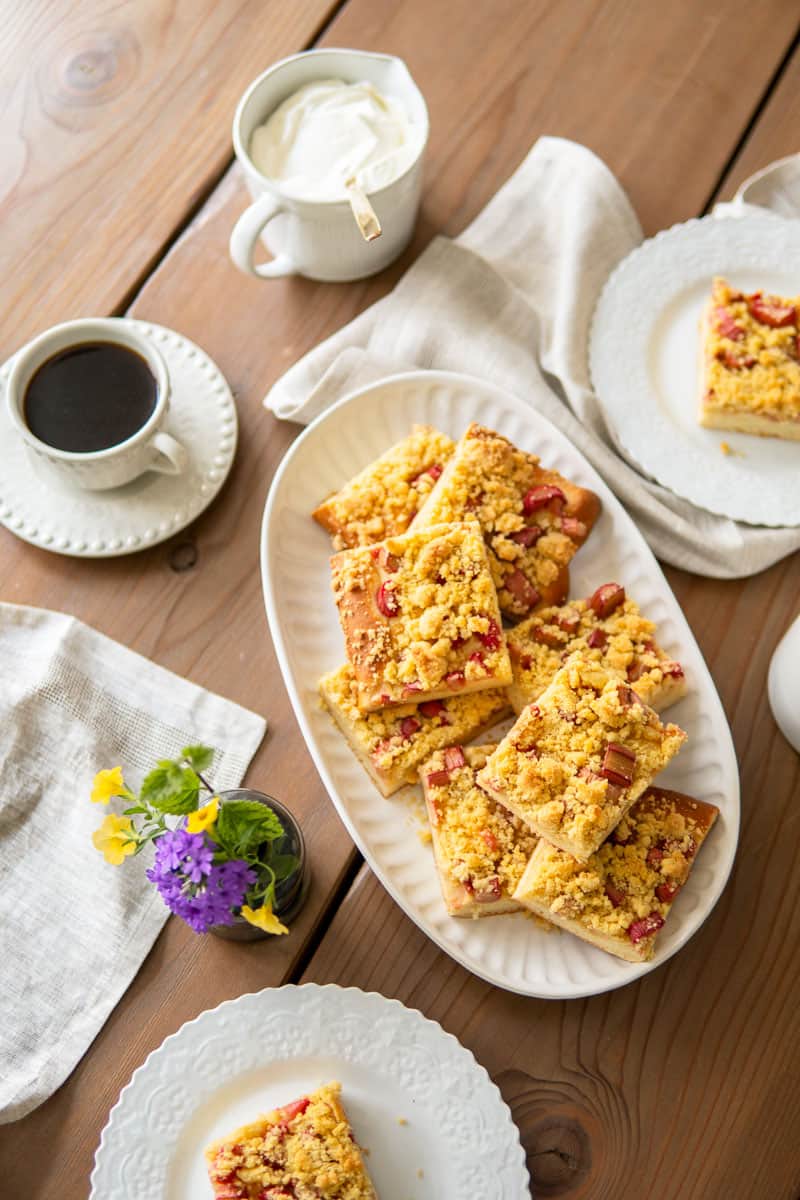 rhubarb cake slices on a platter and on plates