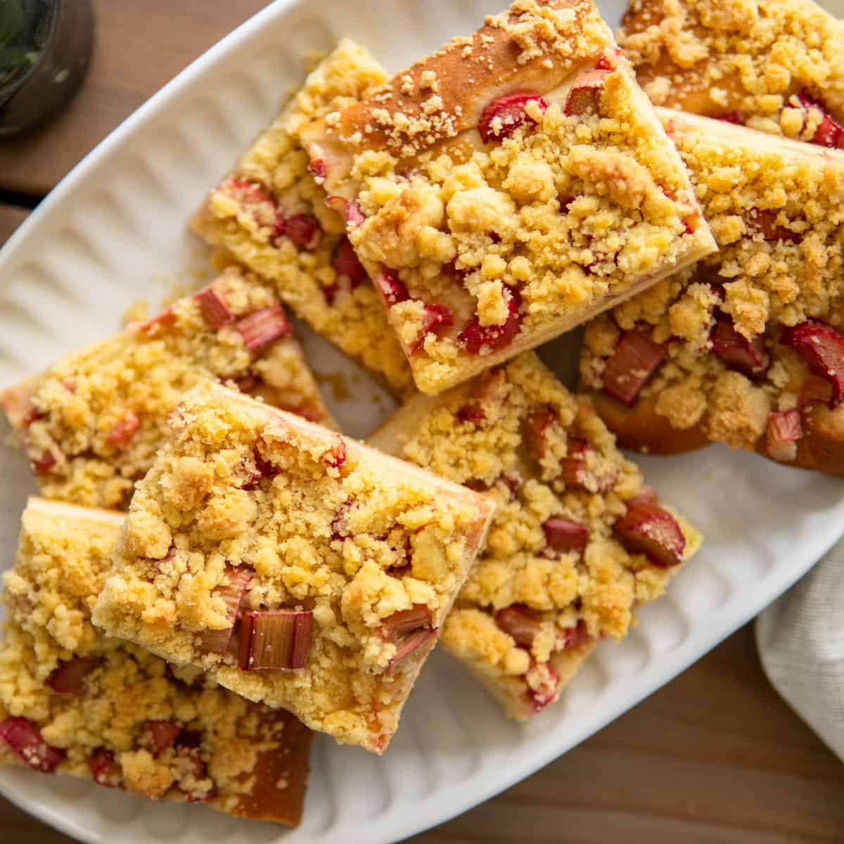 rhubarb cake slices on a white platter