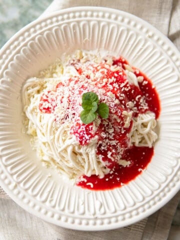 white bowl with spaghetti ice cream topped with a mint leaf