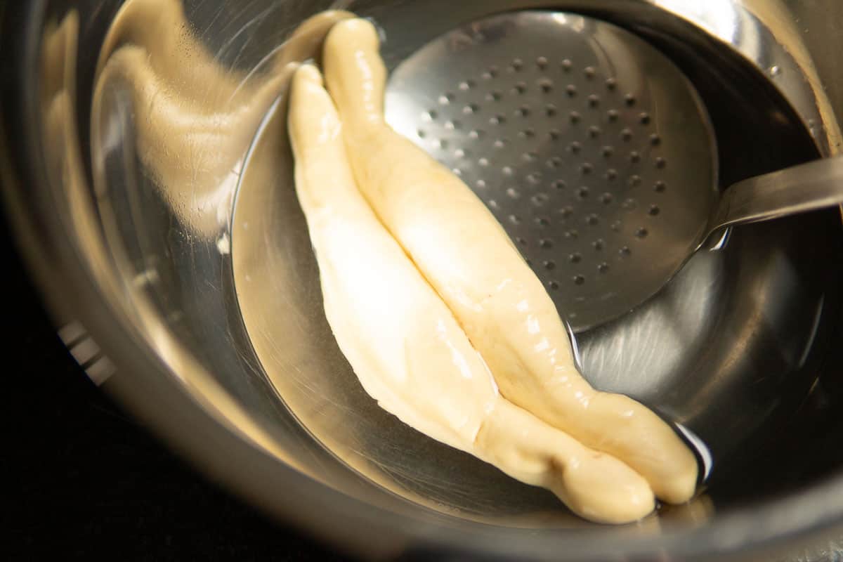 dipping pretzels in lye solution using a steel skimmer