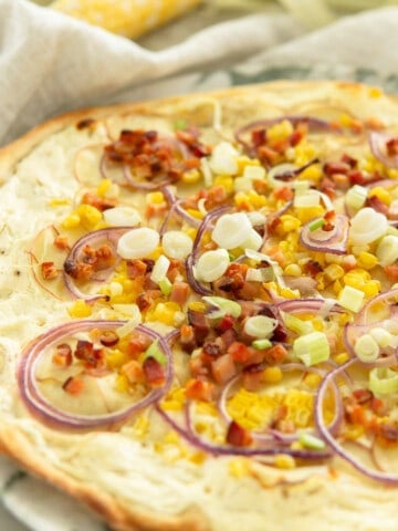 baked summer flamnkuchen topped with corn, bacon, potato and onion