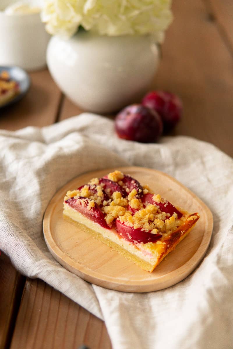 a slice of pflaumenkuchen on a wooden plate