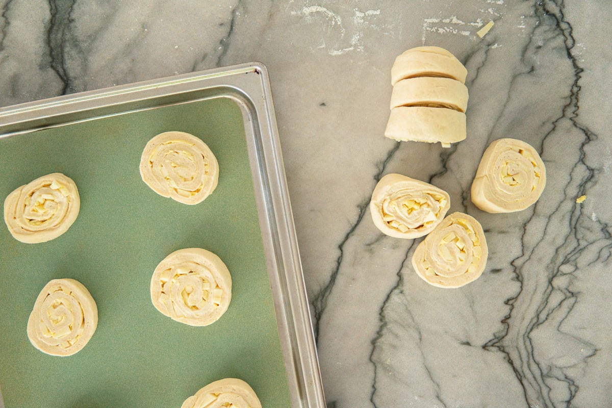 cutting up apple cinnamon rolls