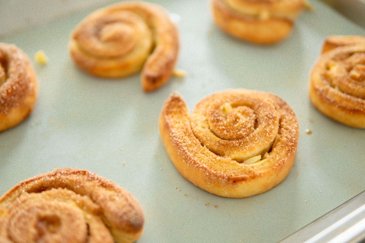 freshly baked apple cinnamon rolls on baking sheet