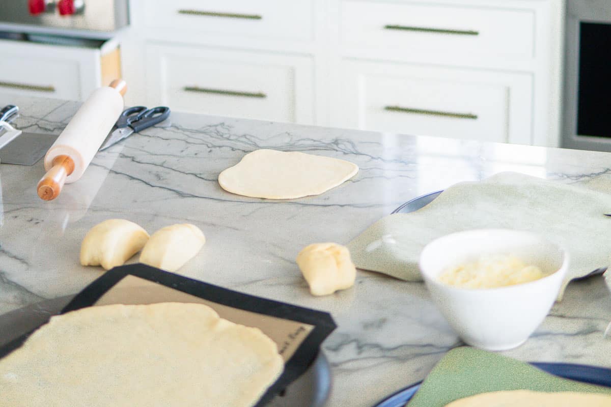 rolling out dough for pretzel pizza
