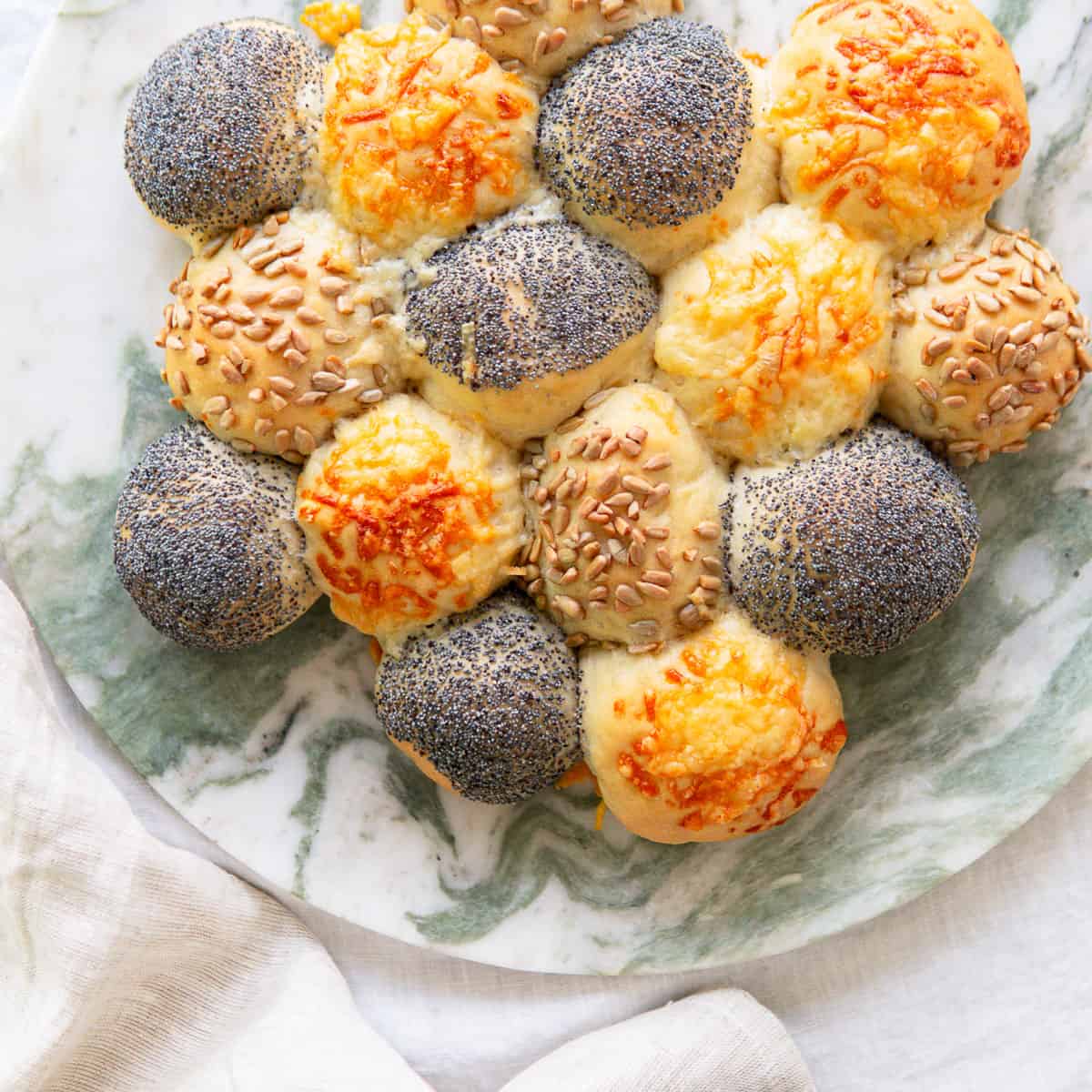 Baked slider buns on a marble platter.