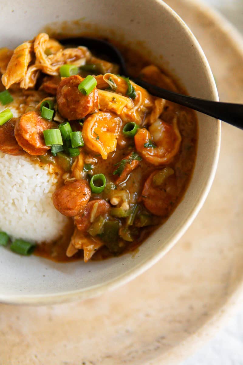Closeup of gumbo in a bowl served over steamed rice.
