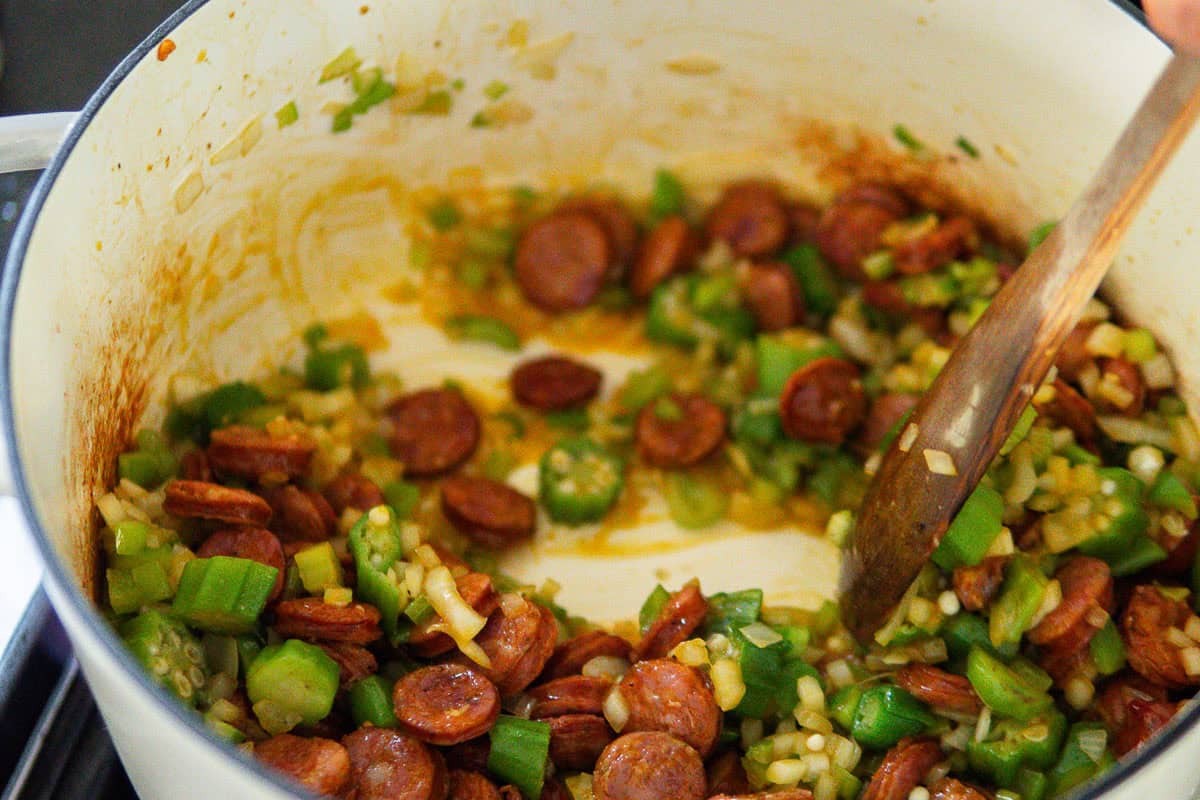 Cooking the andouille sausage and the veggies for gumbo in a large pot.
