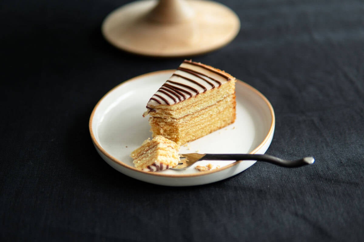 Side view of a slice of Baumkuchen cake sitting on a plate.
