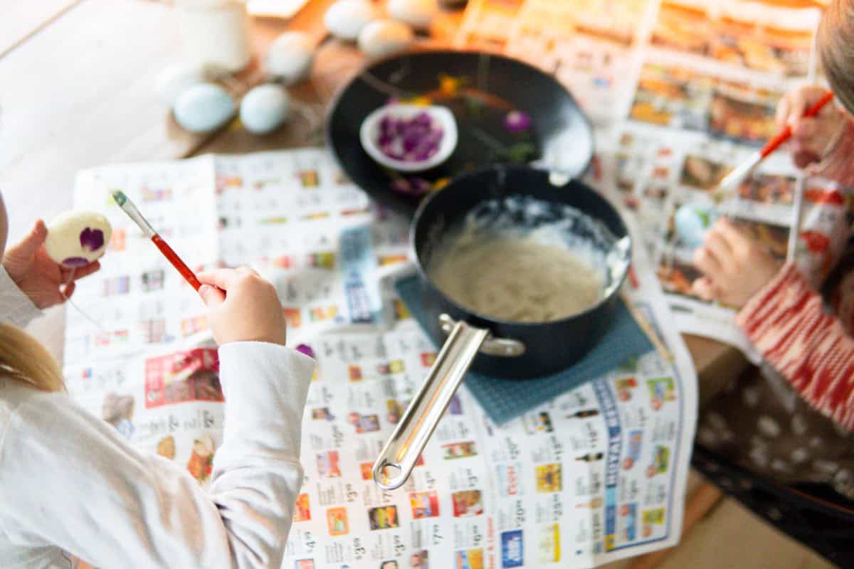 Kids decorating easter eggs with flower petals.