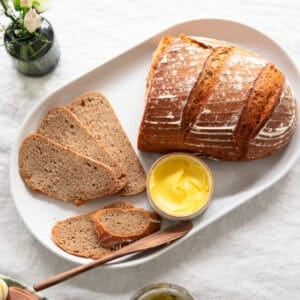 loaf of sourdough bread on counter with slices laying next to it