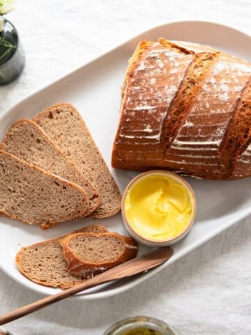 loaf of sourdough bread on counter with slices laying next to it