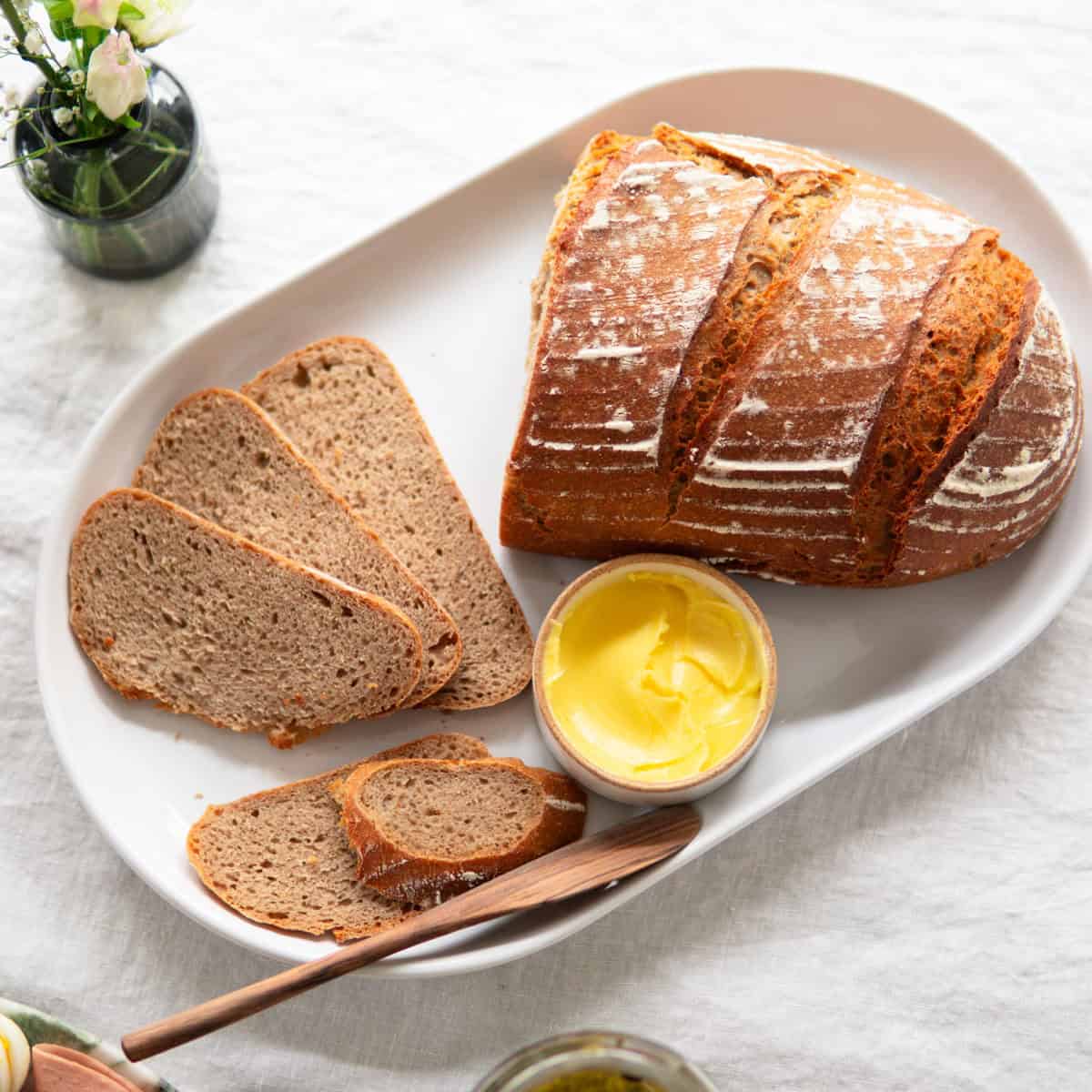 loaf of sourdough bread on counter with slices laying next to it