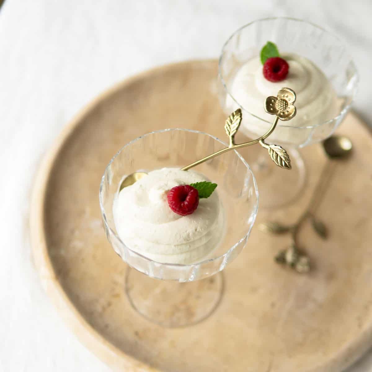 Topfencreme piped into stemmed glasses and garnished with mint and a fresh raspberry.