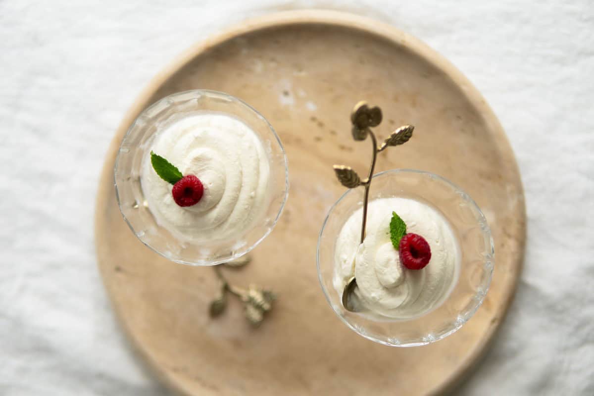 Top view of German quark dessert garnished with mint and raspberry.