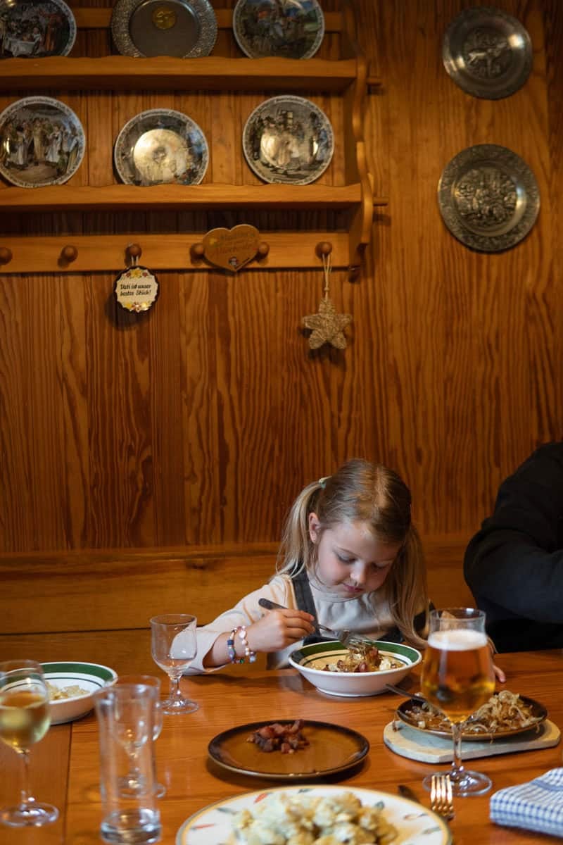 A girl eating mini potato dumplings sitting at my German grandma's dining table.