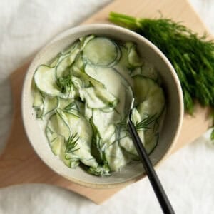 Creamy cucumber salad topped with dill.