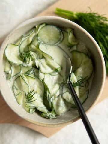 Creamy cucumber salad topped with dill.