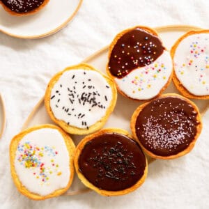 Amerikaner pastries with chocolate and lemon glaze on a platter.